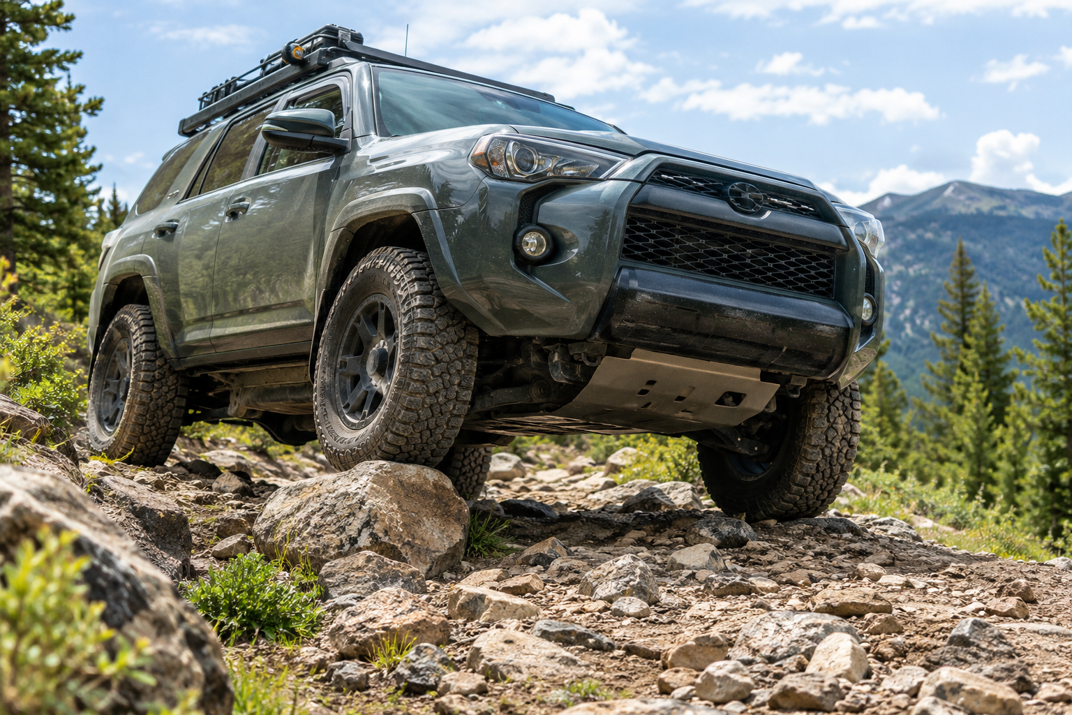 Off-road SUV crossing a rocky trail with visible ground clearance